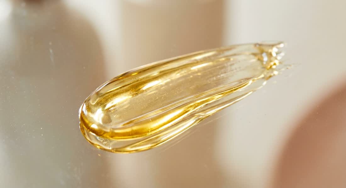 A streak of golden facial oil catching the light